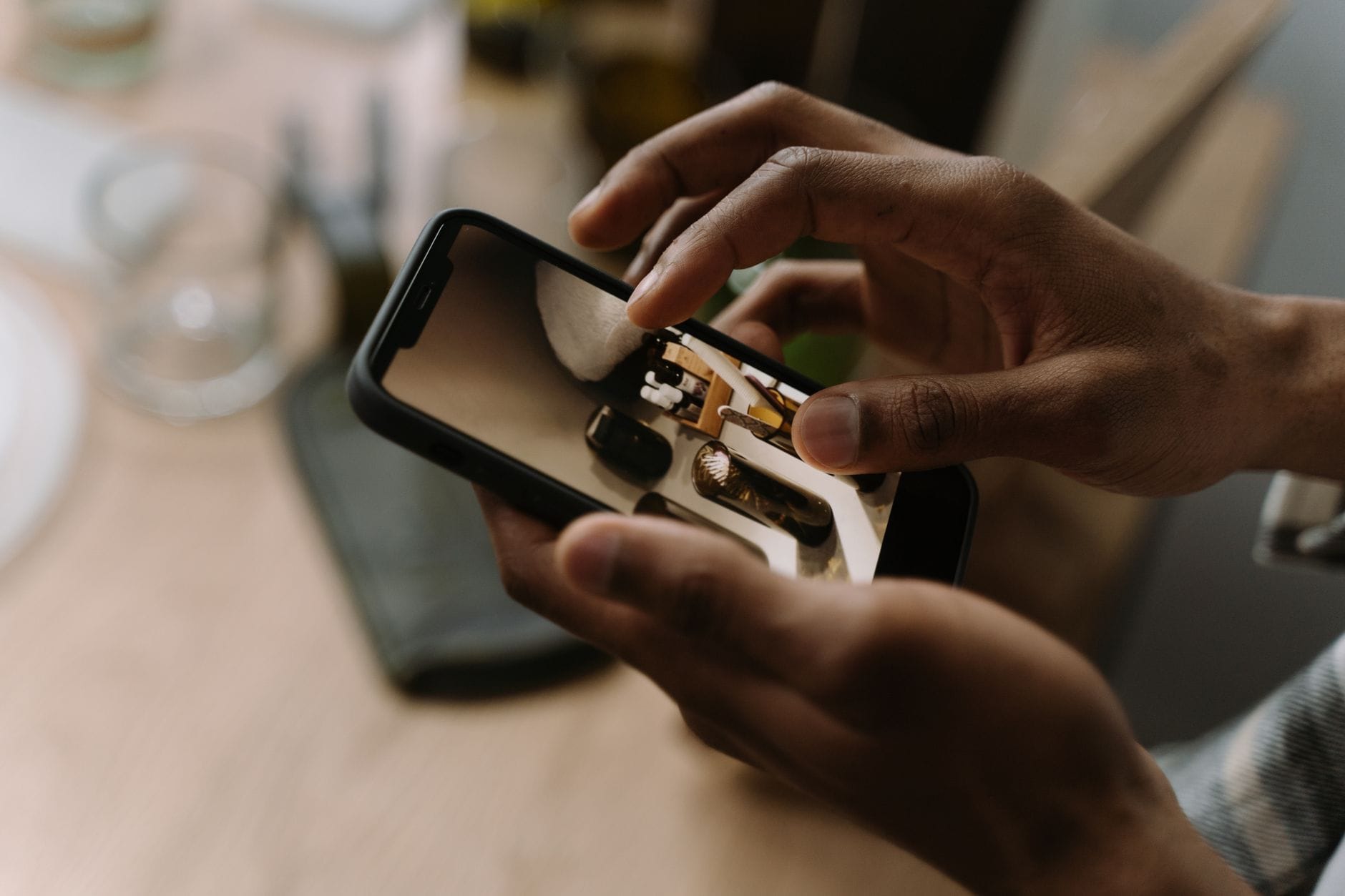Dłonie trzymające smartfon w mieszkaniu podczas robienia zdjęcia