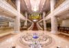 Elegancki hall hotelowy z marmurową posadzką, schodami i żyrandolem