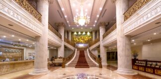 Elegancki hall hotelowy z marmurową posadzką, schodami i żyrandolem