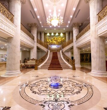 Elegancki hall hotelowy z marmurową posadzką, schodami i żyrandolem