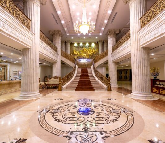Jak powstał luksusowy hall wejściowy z posadzką z marmuru Carrara Elegancki hall hotelowy z marmurową posadzką, schodami i żyrandolem